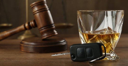 gavel, glass of alcohol, and car key
